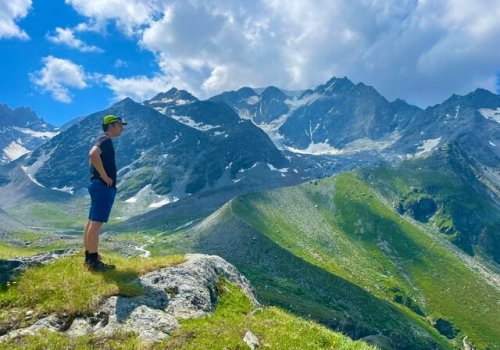 Wanderer genießt die Aussicht auf die Alpen während einer geführten Wandertour in der Schweiz.